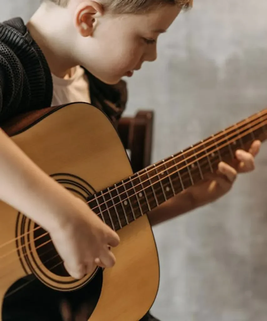 A child practising acoustic guitar