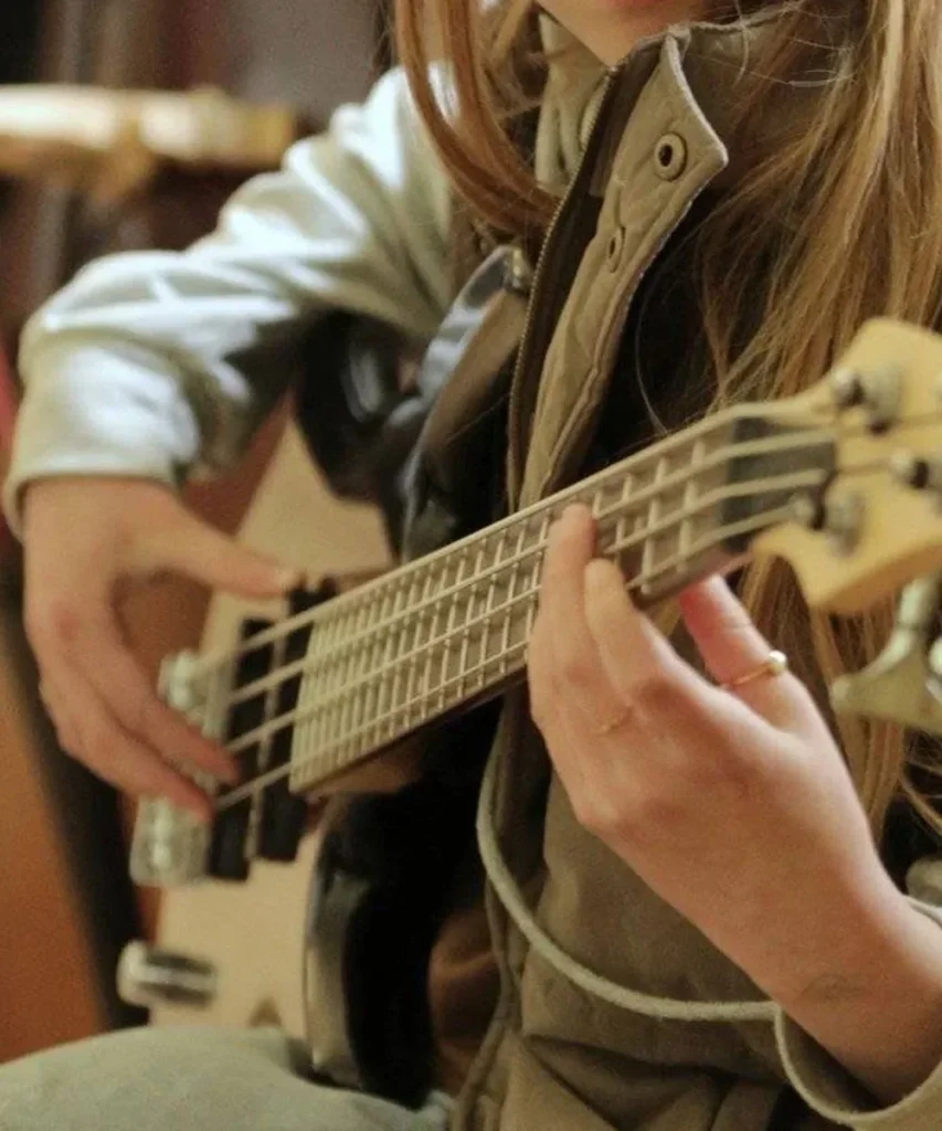 A young musician playing bass guitar