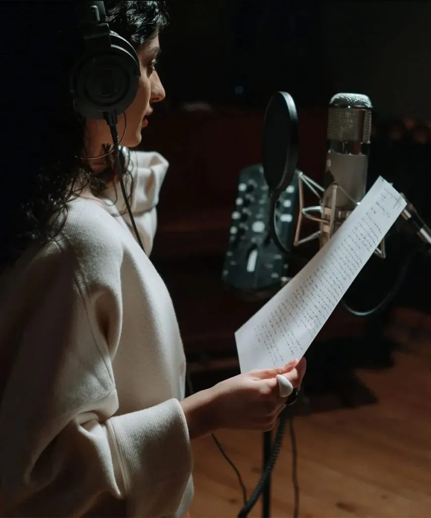 A singer practising vocals with a microphone and sheet music